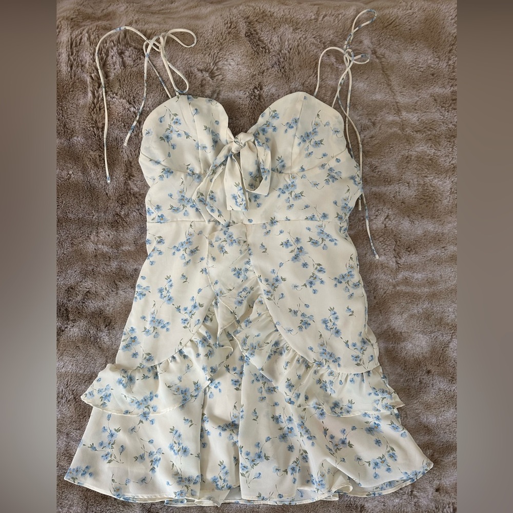 Sundress with adjustable tie straps and bow detail at décolletage. Never worn.